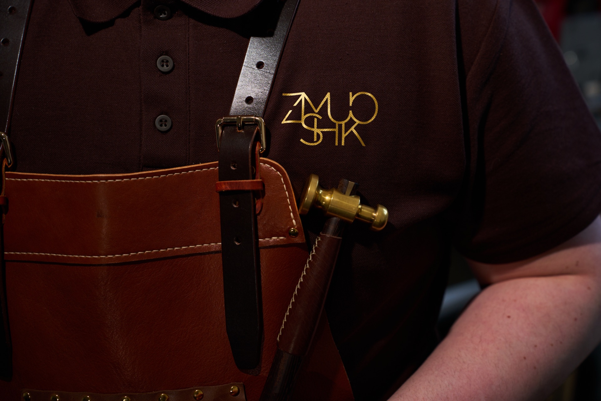 A craftsman in his Zmushko apron, dark workshop scene